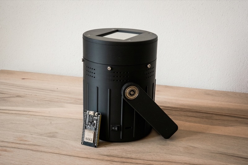 Camping-Lautsprecher: schwarzes zylindrisches 3D-gedrucktes Gehäuse mit Henkel, davor eine ESP32-Platine